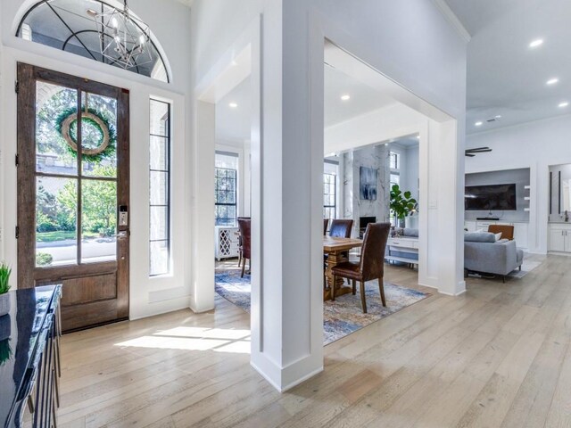 entrance foyer featuring plenty of natural light, a notable chandelier, and light wood-type flooring