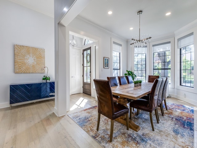 dining room with light hardwood / wood-style flooring, a chandelier, and ornamental molding