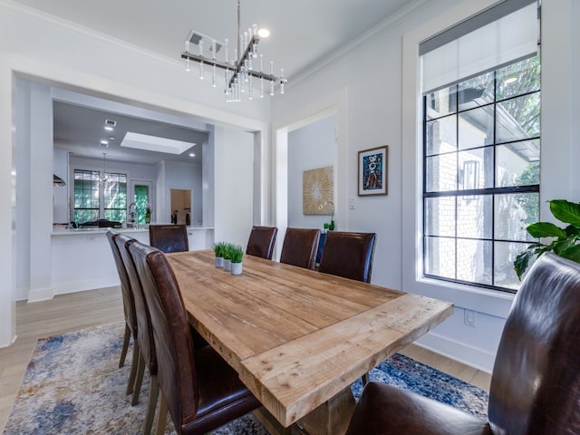 dining area featuring ornamental molding, a healthy amount of sunlight, and light hardwood / wood-style floors