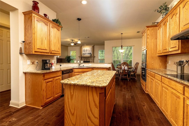 kitchen featuring kitchen peninsula, decorative light fixtures, sink, dark hardwood / wood-style flooring, and black appliances