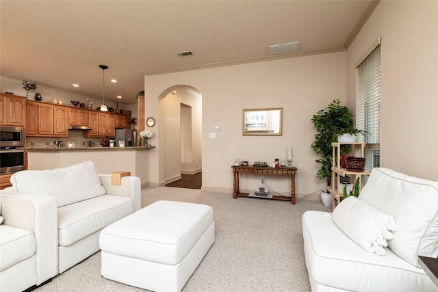 living room featuring arched walkways, crown molding, recessed lighting, light colored carpet, and baseboards