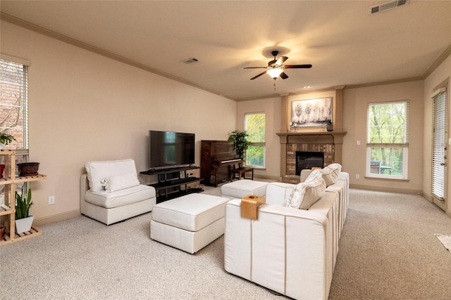 living area with a healthy amount of sunlight, a fireplace, visible vents, and light colored carpet