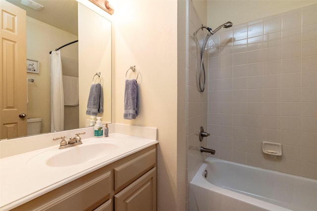 bathroom featuring toilet, shower / bath combo with shower curtain, and vanity