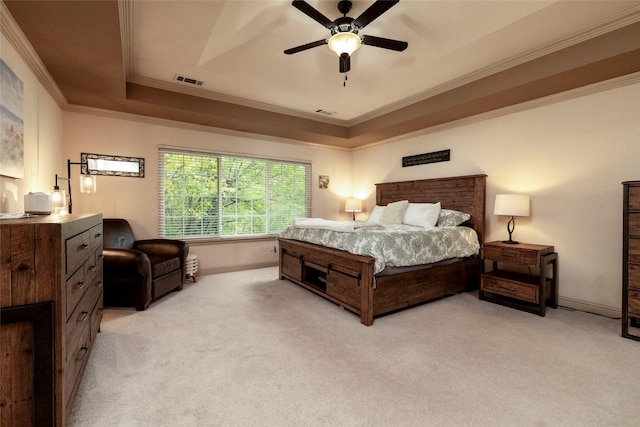 bedroom with crown molding, ceiling fan, a tray ceiling, and light colored carpet