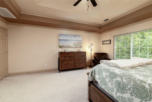 bedroom featuring crown molding, light colored carpet, ceiling fan, and a tray ceiling