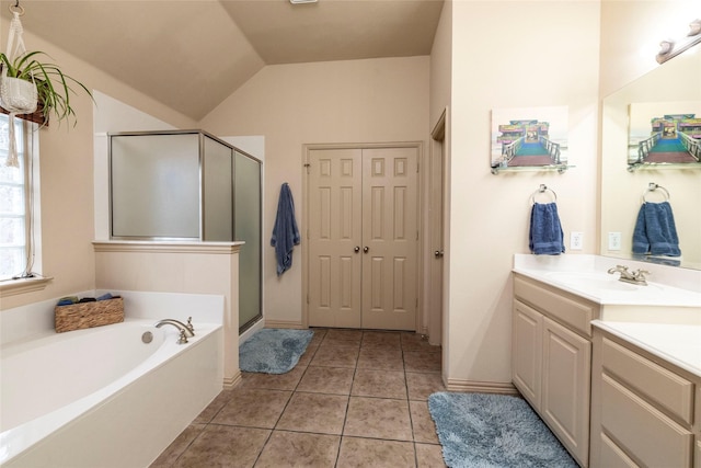 bathroom with tile patterned flooring, vaulted ceiling, shower with separate bathtub, and vanity