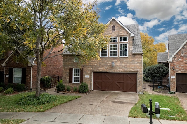 traditional-style house featuring concrete driveway, roof with shingles, an attached garage, fence, and brick siding