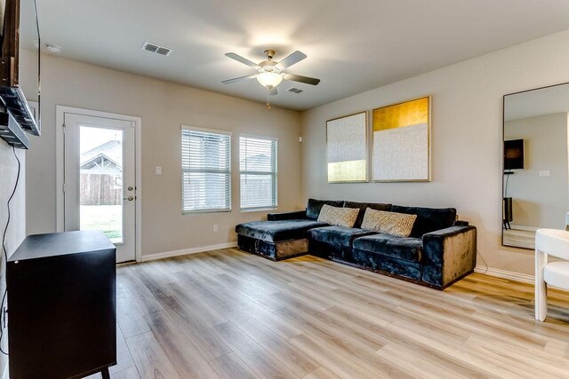 living room with light hardwood / wood-style flooring and ceiling fan