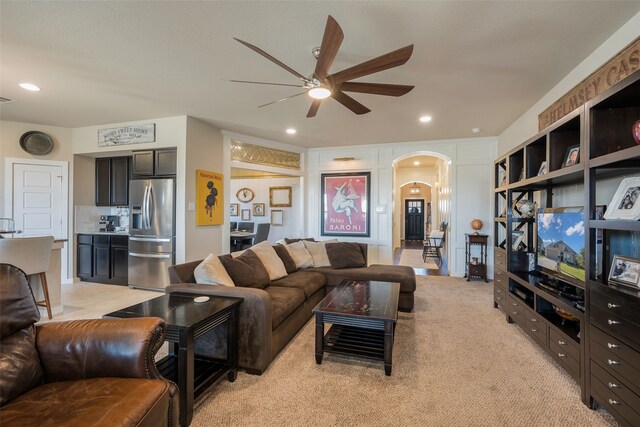 carpeted living room with ceiling fan