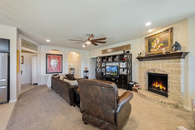 living room with light carpet, a fireplace, and ceiling fan