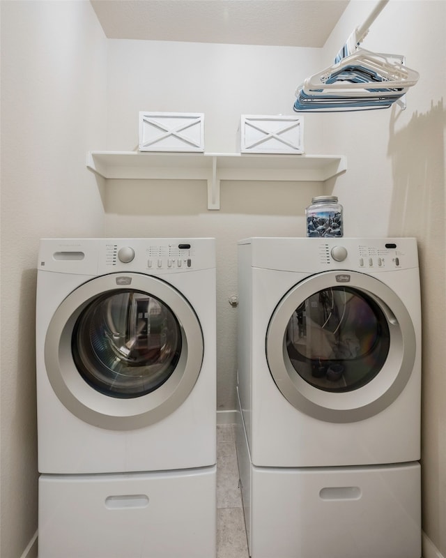 laundry room featuring washer and dryer and light tile patterned flooring