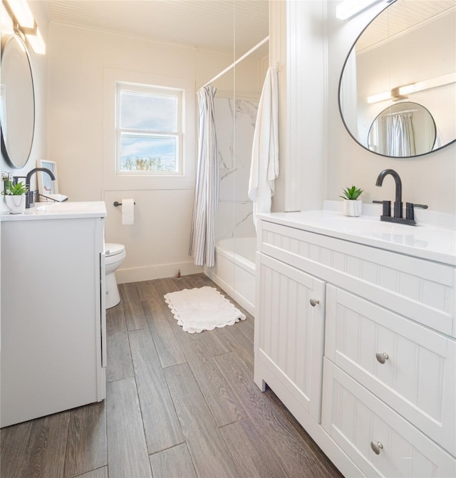 full bath featuring shower / bath combination with curtain, a sink, toilet, and wood finished floors