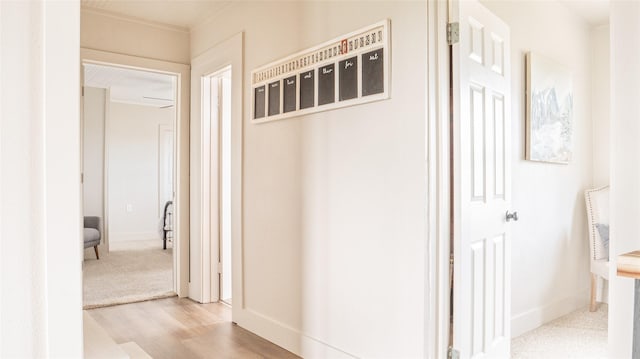 hall with light wood-type flooring and baseboards