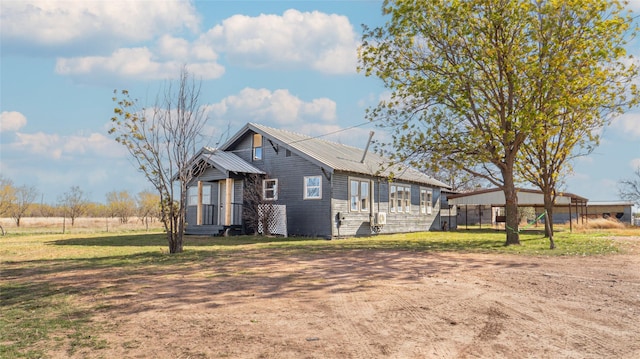 view of front of home featuring entry steps, metal roof, and a front yard