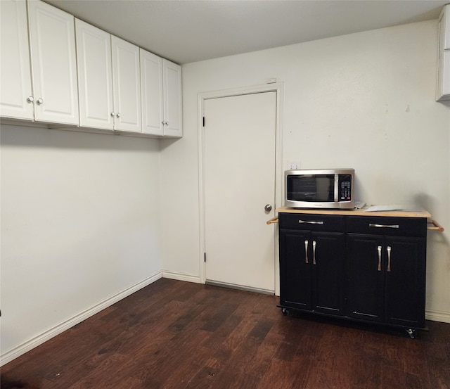 clothes washing area with dark wood-type flooring