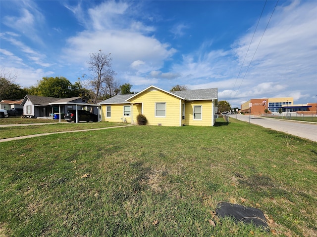 ranch-style house featuring a carport and a front lawn