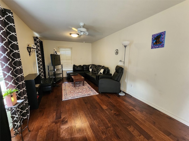 living room featuring dark wood-type flooring and ceiling fan