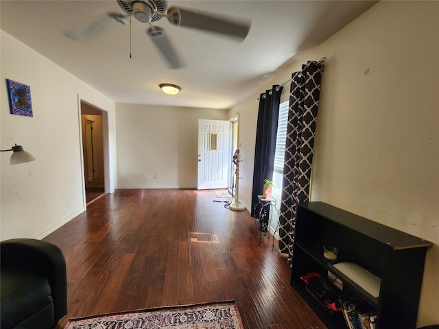 living room with ceiling fan and dark wood-type flooring