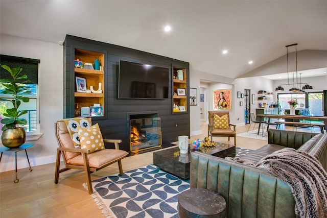 living room featuring a fireplace, light wood-type flooring, and lofted ceiling