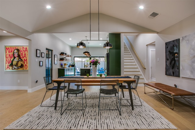 dining space with light wood-type flooring and lofted ceiling