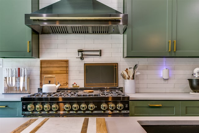 kitchen with backsplash, wall chimney exhaust hood, and green cabinetry