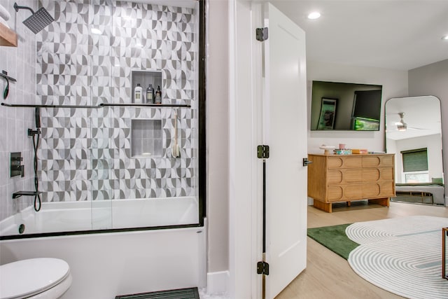 full bathroom featuring vanity, hardwood / wood-style flooring, ceiling fan, toilet, and enclosed tub / shower combo