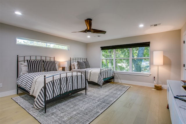 bedroom featuring multiple windows, ceiling fan, and light hardwood / wood-style floors