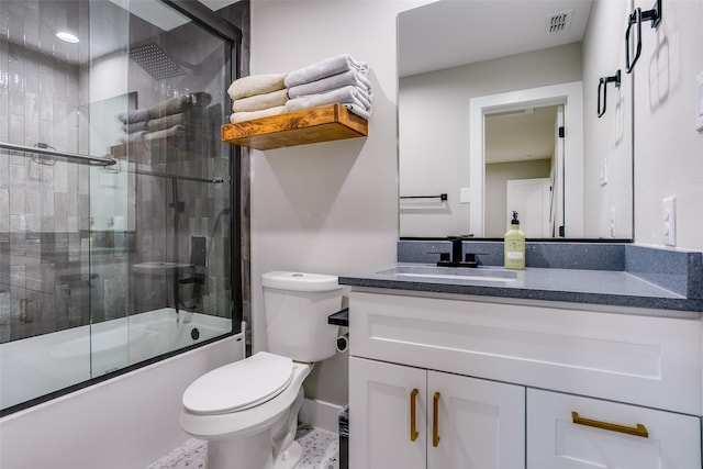 full bathroom featuring vanity, bath / shower combo with glass door, and toilet