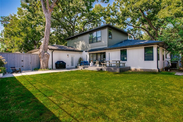 back of house with a patio and a lawn