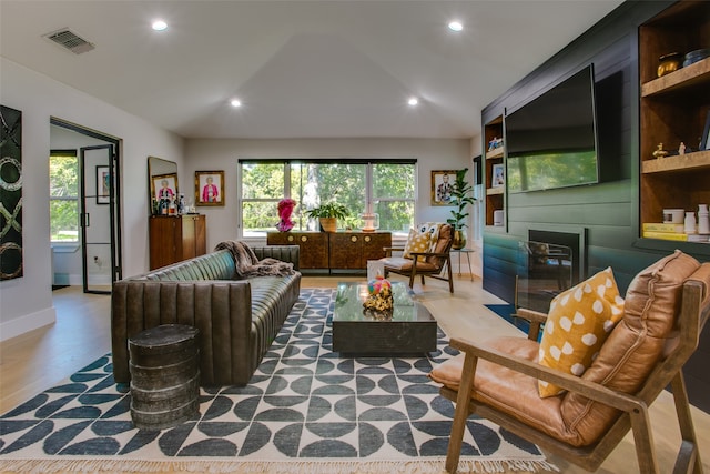 living room with hardwood / wood-style flooring and vaulted ceiling