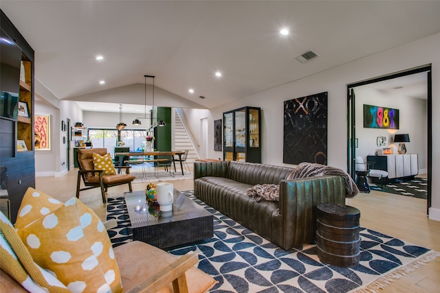 living room featuring lofted ceiling and light hardwood / wood-style floors