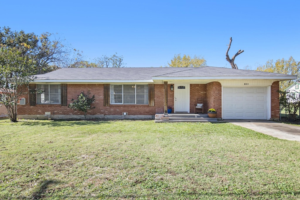 single story home featuring a garage and a front yard