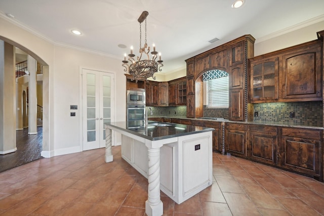 kitchen featuring a center island with sink, stainless steel appliances, sink, and tasteful backsplash