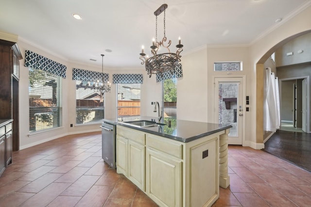 kitchen with an inviting chandelier, sink, an island with sink, cream cabinetry, and decorative light fixtures