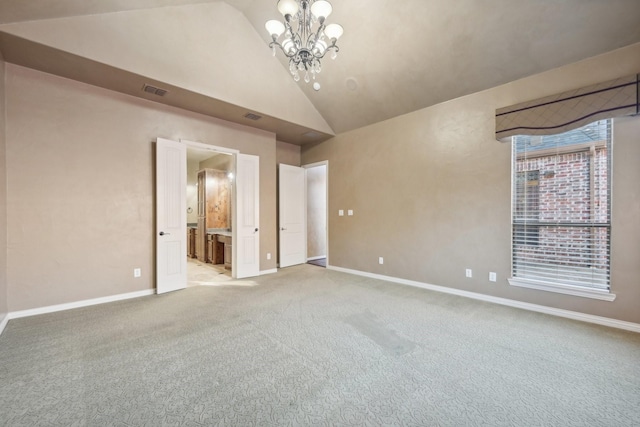 spare room with carpet flooring, lofted ceiling, and a notable chandelier