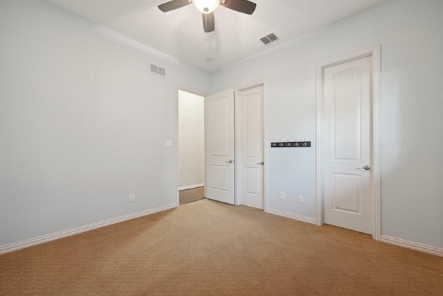 unfurnished bedroom with ceiling fan and light colored carpet