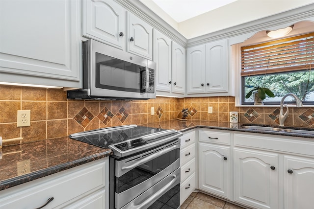 kitchen with white cabinetry, sink, decorative backsplash, and stainless steel appliances