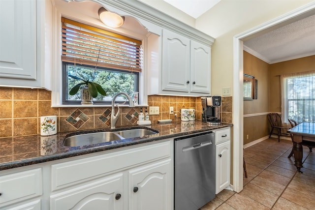 kitchen featuring white cabinetry, sink, stainless steel dishwasher, and dark stone countertops