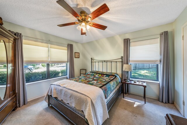 bedroom featuring carpet floors, multiple windows, and a textured ceiling