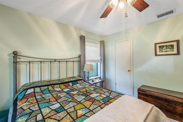 bedroom with ceiling fan and a textured ceiling