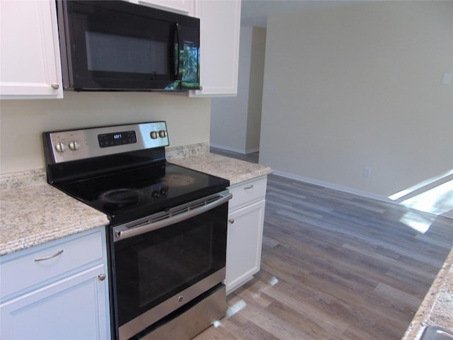 kitchen featuring stainless steel range with electric stovetop, white cabinetry, light hardwood / wood-style flooring, and light stone countertops