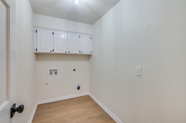 laundry room featuring electric dryer hookup, hookup for a washing machine, cabinets, light hardwood / wood-style floors, and hookup for a gas dryer