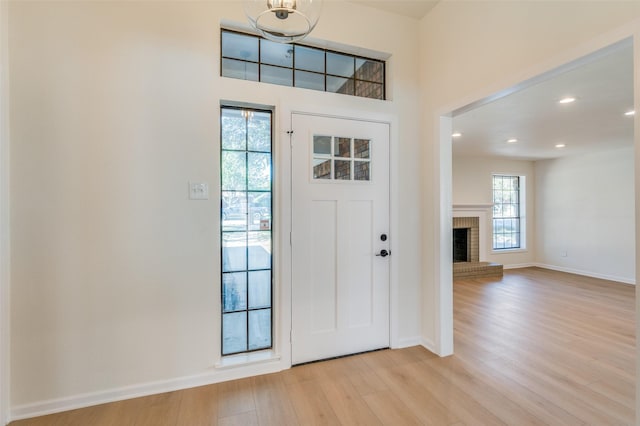 entrance foyer featuring light wood-type flooring and a fireplace