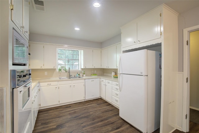 kitchen with sink, white appliances, white cabinets, and dark hardwood / wood-style floors