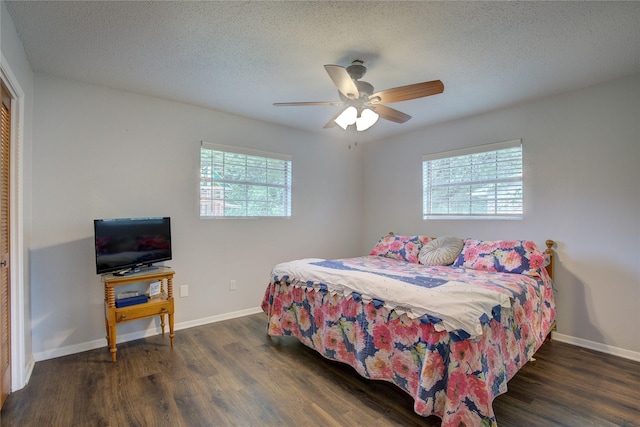 bedroom with ceiling fan, dark wood-type flooring, multiple windows, and a textured ceiling