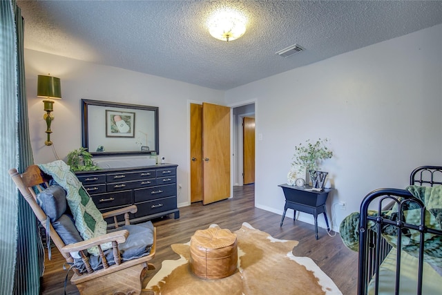 living area with a textured ceiling and dark hardwood / wood-style floors