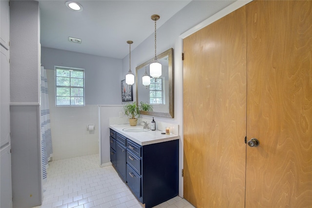 bathroom featuring tile walls, walk in shower, vanity, and tile patterned flooring