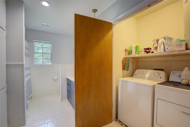 washroom with light tile patterned floors and washing machine and clothes dryer