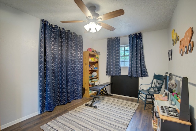 interior space featuring a textured ceiling, ceiling fan, and dark hardwood / wood-style flooring