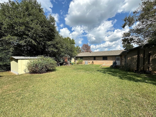 view of yard featuring a playground and a storage unit